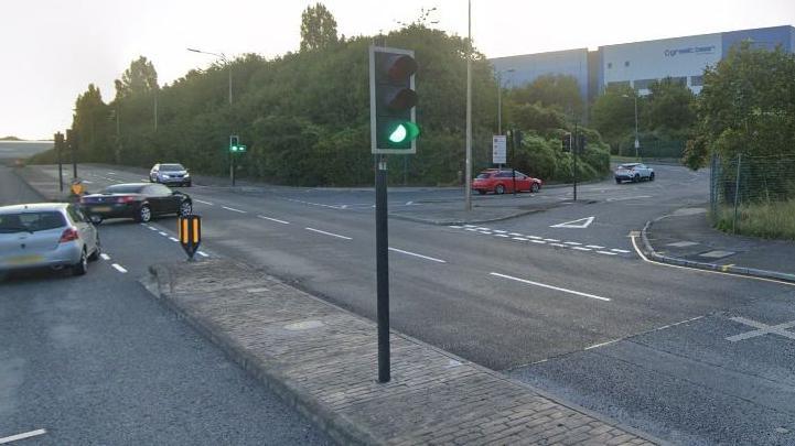 The junction of Carwood Road and Petre Street in Sheffield with a traffic light on green in the foreground centre of the picture.