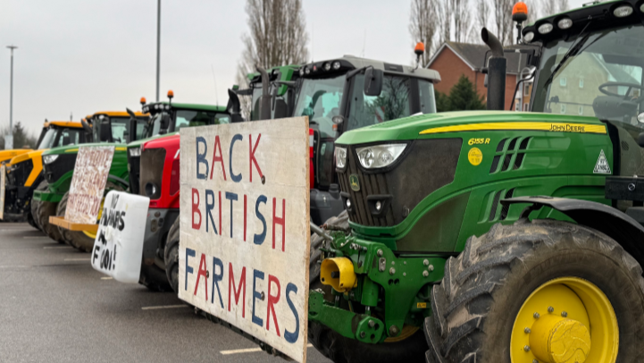 A row of tractors bearing signs, parked up.