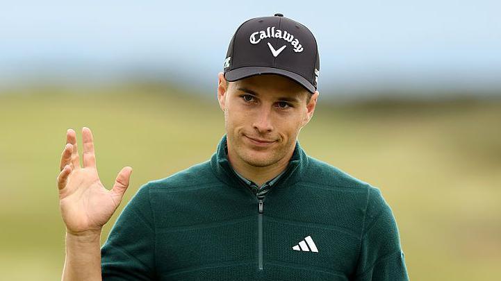 Matthew Jordan raises his hand to acknowledge the crowd at the Dunhill Links Championship
