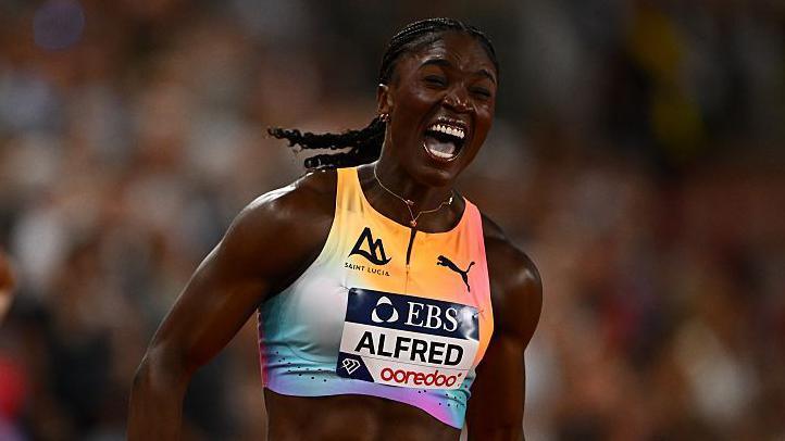 Julien Alfred celebrates winning the women's 200m in Monaco