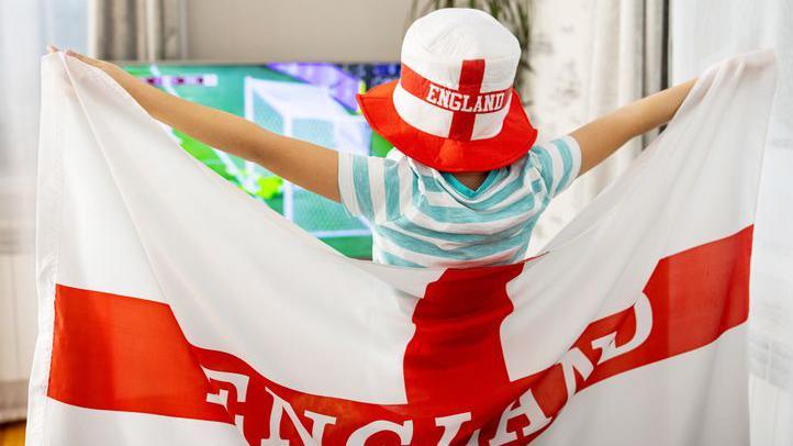 child in england flag watching football