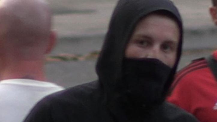 A man with his hood up and a face covering. 