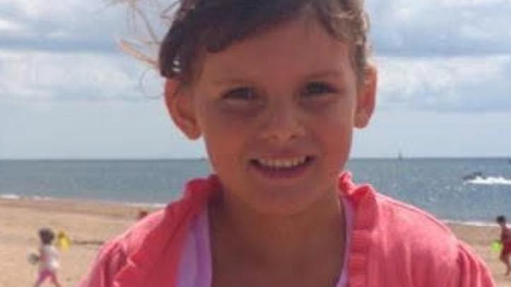 A photo of Tamzin Hall by the beach in the sun. She is smiling.