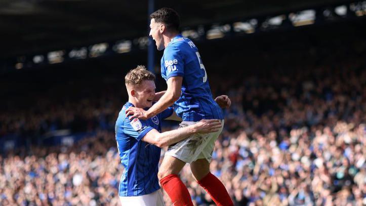 Portsmouth's Terry Devlin jumps into the arms of Regan Poole in celebration after beating Leeds United.