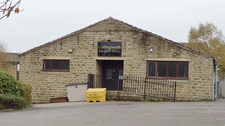 Cullingworth Village Hall in Bradford, pictured from the outside. The brick building has an accessible ramp up to the main entrance. 