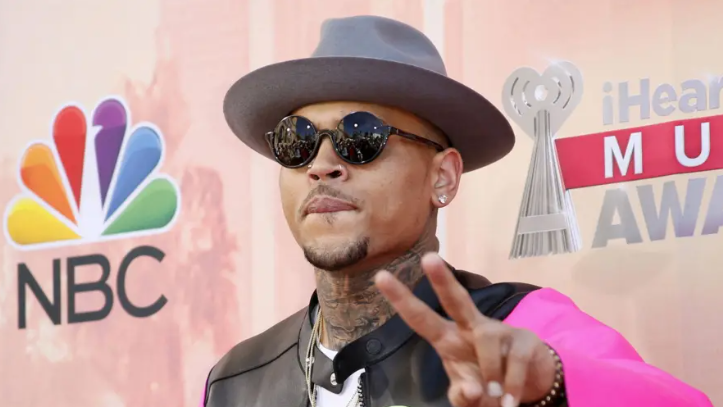 Chris Brown wearing a hat and shades at a showbiz event