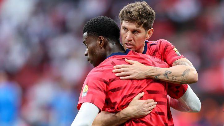 Marc Guehi and John Stones hug