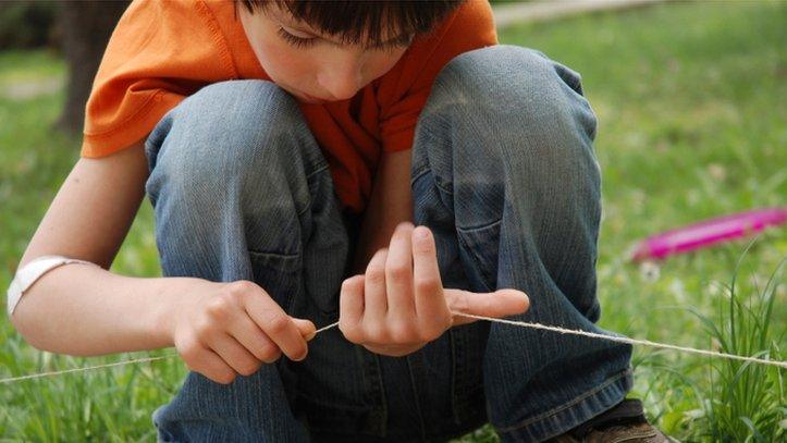 Generic photo of boy threading string through his hands