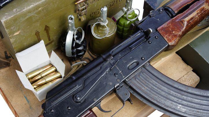 Picture shows an AK47 rifle next to ammunition, including bullets and grenades 