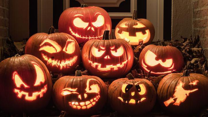 Eight differently carved pumpkins.