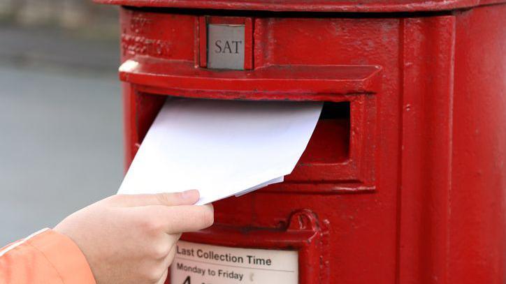 person posting in letterbox