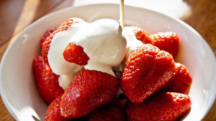 A bowl of strawberries and cream.