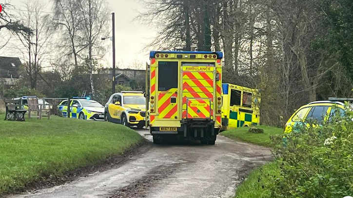 Two ambulances and several police cars parked in countryside