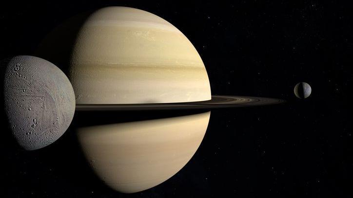 Enceladus orbiting around Saturn, together with Mimas. 