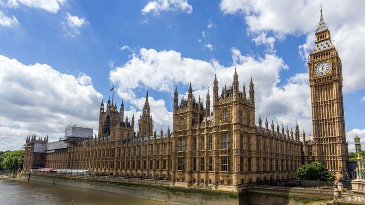 House of Commons and Palace of Westminster next to Thames river in London.