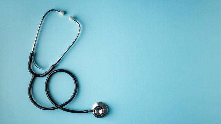 Black stethoscope on a blue background.