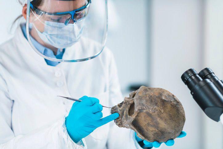 Ancient DNA analysis. Female scientist holding micro tube with sample in ancient DNA laboratory.