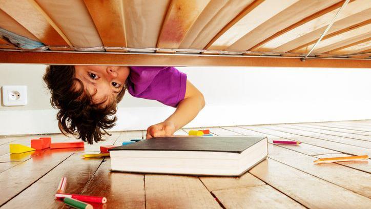 A child looking under the bed.