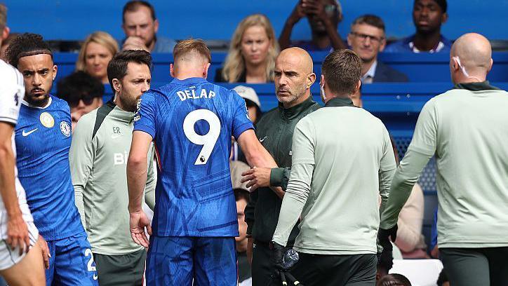 Chelsea striker Liam Delap comes off injured against Fulham and shakes hands with manager Enzo Maresca as he departs the pitch