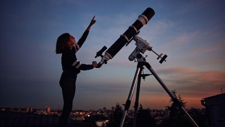 Girl pointing to the sky.