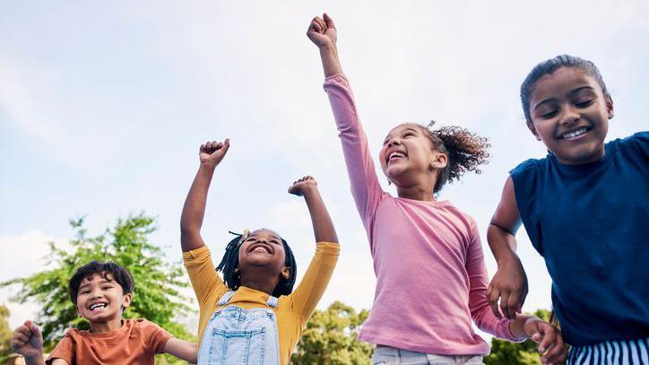 Children celebrating with their arms in the air.