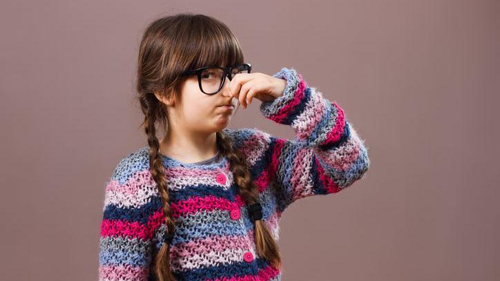 A girl holding her nose.