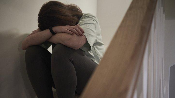 A distressed woman sitting on the stairs