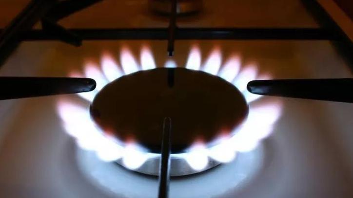 A closeup of a gas cooking hob with a white and red flame.