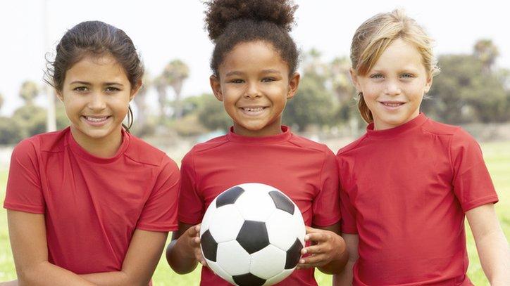 Girls holding a football