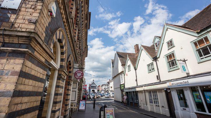 A view of Bridgnorth town centre in Shropshire, with shop windows and signs on both sides of the streets and boards outside the doors.