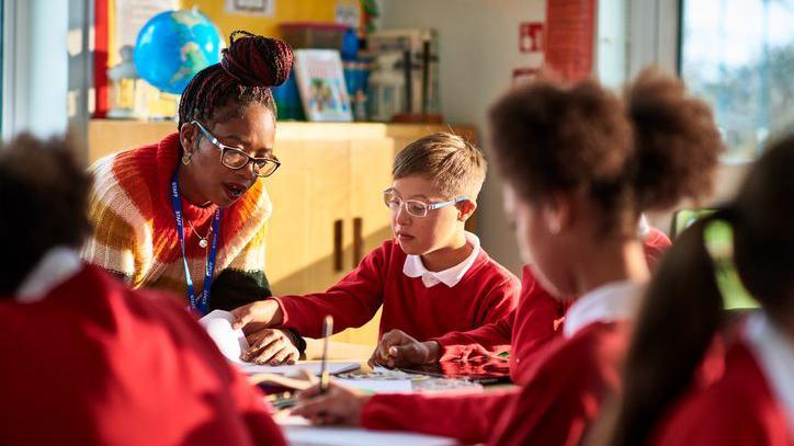 Teacher helping a pupil in class.