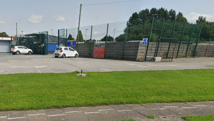 The front entrance to Avro's stadium with a handful of cars in the car park