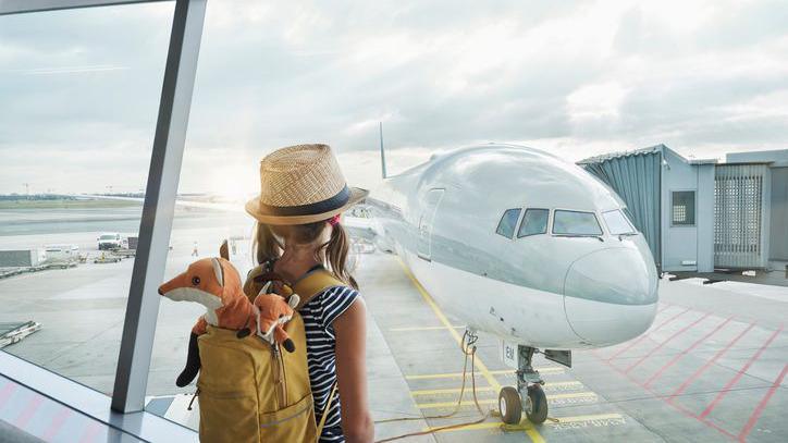 Girl looking at a plane at the airport.