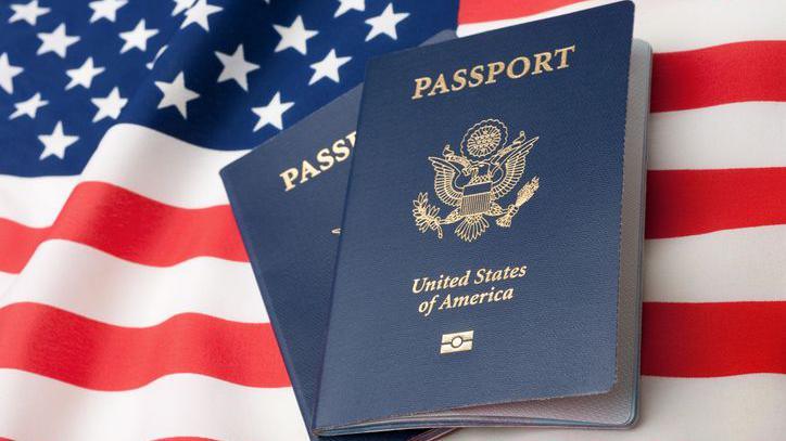 Two US passports against the backdrop of the US flag