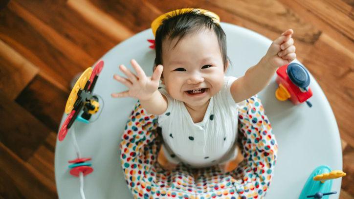 A young toddler having fun in her activity chair.