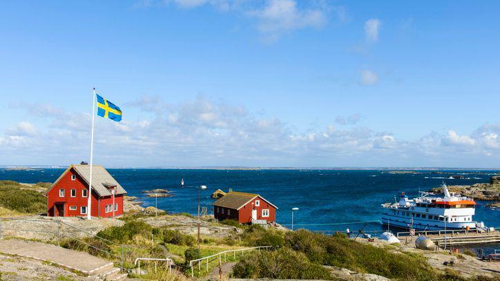 A Swedish island with the flag of Sweden flying high on a pole.
