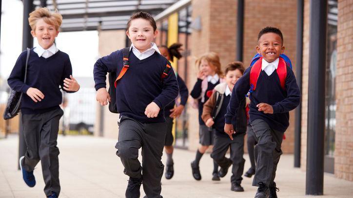 Happy schoolchildren running towards the camera.