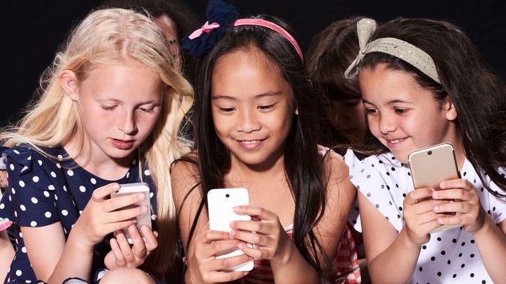 Three girls looking at their phones