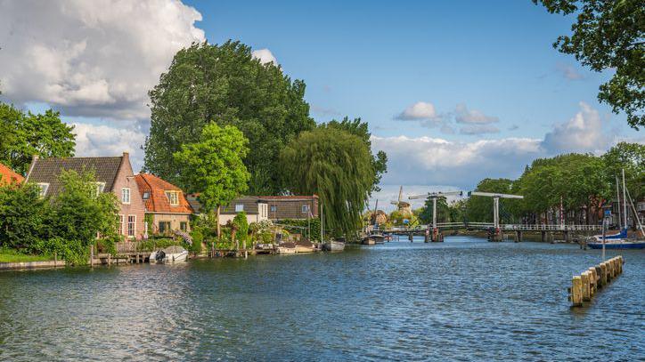Trees and houses lining the river Vecht in the Netherlands.