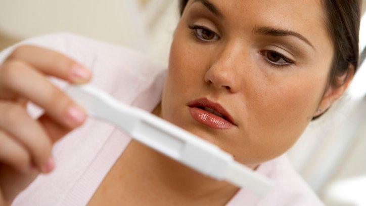 Posed photo of woman looking at pregnancy test