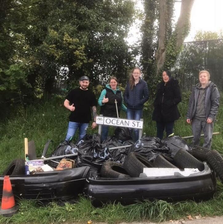 The group surrounded by bags of rubbish they've collected