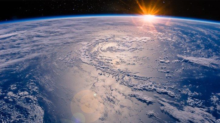 earth, with sun in the distance
