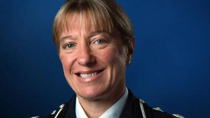 Jo Shiner is wearing a police uniform and is looking into the camera and smiling