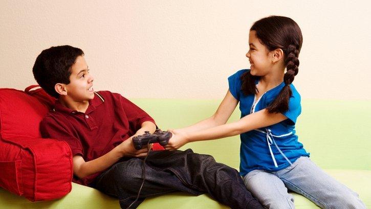 Two children fighting over a games controller