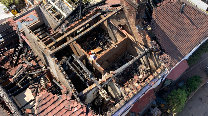 An aerial view of a house roof that has been burned and collapsed