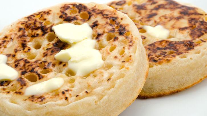 A close-up of two crumpets covered in melted butter