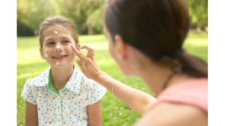 girl having sun cream applied