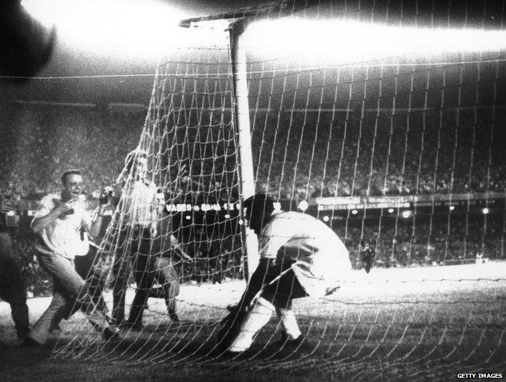 Pele picks the ball from the net after scoring his 1000th goal at the Maracana Stadium. He scored from a penalty for the Brazilian team, Santos, 19 November 1969.