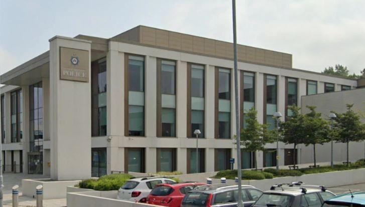 A West Yorkshire Police building, with a car park and some young trees also in shot. 