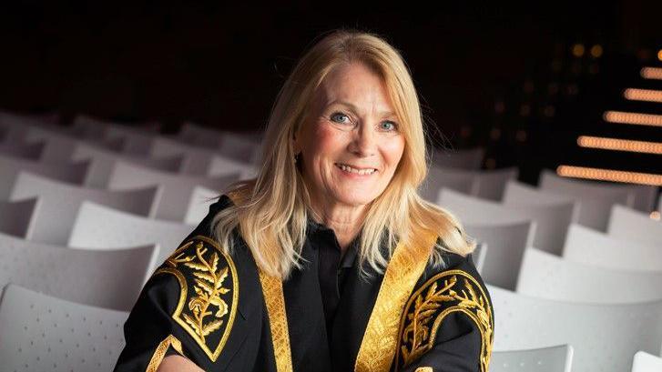 Portrait photo of the University of Bradford's vice chancellor Shirley Congdon wearing a black academic robe with gold embroidery on the shoulders, sleeves and lapels